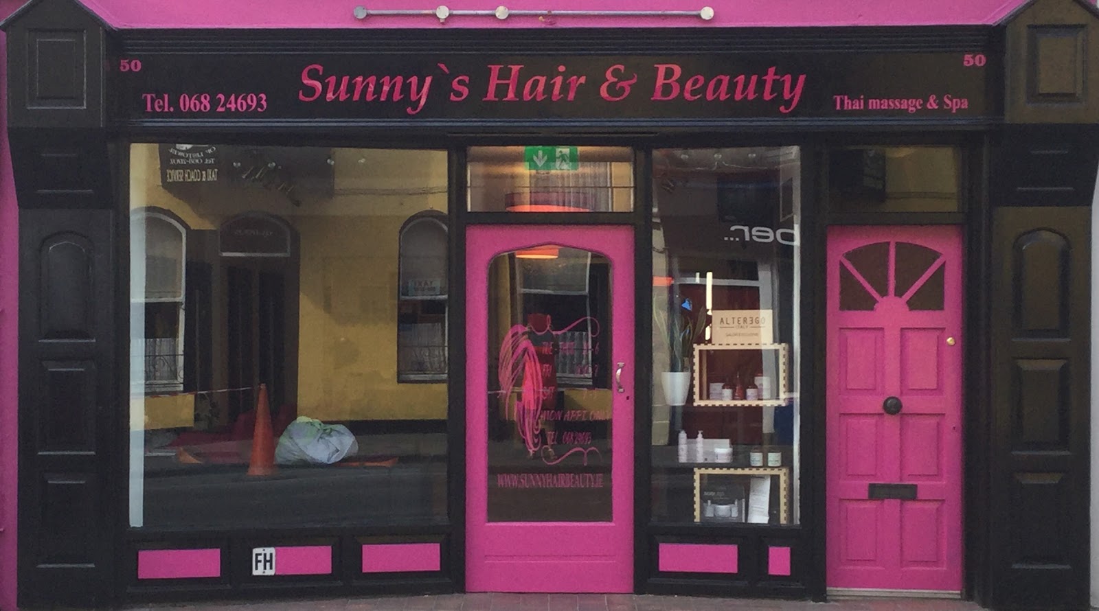 The shopfront of Sunny's Hair & Beauty at 50 Church Street, Listowel — black fascia, pink doors, Thai massage on the sign